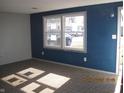 Neutral-toned living room featuring carpeted floors, a large window, and modern paint at 5820 N Nebo Rd, Muncie, IN 47304