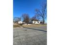 Exterior view of a home with a detached garage and expansive yard under clear blue skies at 6944 E 300 S, Greenfield, IN 46140