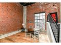 Dining room with exposed brick, wood floors, large windows, and a modern staircase at 735 Lexington Ave # 30, Indianapolis, IN 46203