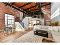 Spacious living room featuring an open floor plan, exposed brick, modern staircase, and an open kitchen at 735 Lexington Ave # 30, Indianapolis, IN 46203