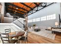 Open living space featuring an open floor plan, exposed brick, modern staircase, and wood floors at 735 Lexington Ave # 30, Indianapolis, IN 46203