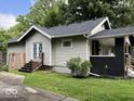 Rear view of a cozy home featuring a small porch, well-maintained siding, and lush greenery at 744 Wallace Ave, Indianapolis, IN 46201