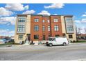 Exterior view of newly built condominiums featuring mixed brick and siding, situated near street parking and blue skies at 76 E Wayne St # B, Franklin, IN 46131
