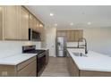 Modern kitchen with stainless steel appliances, a kitchen island with white countertop, and light wood cabinetry at 9742 Behner Dr, Fishers, IN 46250