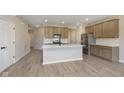 Open-concept kitchen with a large island, stainless steel appliances, and views of the entryway and living area at 9742 Behner Dr, Fishers, IN 46250