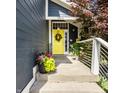 Close-up of a vibrant yellow front door with wreath, flowers, and a 'Welcome' sign at 1424 S New Jersey St, Indianapolis, IN 46225