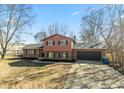 Two-story home featuring a two-car garage, brick accents, and a long driveway at 1431 W Edgewood Ave, Indianapolis, IN 46217