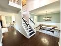 Bright foyer with staircase, hardwood floors, and dining room with elegant chandelier at 1470 Northern Valley Trl, Avon, IN 46123