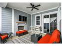Stylish covered back patio featuring a fireplace, comfortable seating, and a ceiling fan at 15297 Fairlands Dr, Westfield, IN 46074