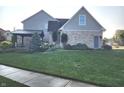 Beautifully landscaped backyard featuring a covered patio area, mature trees, and lush green grass at 16 Torrey Pine Dr, Brownsburg, IN 46112