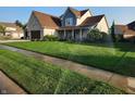 Attractive two-story home with blue and brick accents, an attached garage, and a perfectly manicured lawn at 16 Torrey Pine Dr, Brownsburg, IN 46112