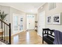 Bright foyer with wood floors, white trim, and a bench creating a warm and inviting atmosphere at 16808 Audley Ave, Westfield, IN 46074