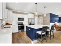 Modern kitchen featuring white cabinets, stainless steel appliances, and an island with bar stool seating at 1684 Hedley W Way, Avon, IN 46123