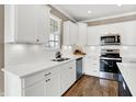 Modern kitchen with white cabinets, quartz countertops, stainless steel appliances, and hardwood flooring at 1684 Hedley W Way, Avon, IN 46123