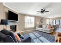 Inviting living room with a stone fireplace, ceiling fan, hardwood floors, and an abundance of natural light at 1684 Hedley W Way, Avon, IN 46123