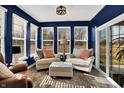 Cozy sunroom with three walls of windows providing natural light, comfortable seating, and scenic outdoor views at 1684 Hedley W Way, Avon, IN 46123