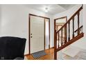 Bright entryway featuring hardwood floors, white walls, a staircase, and a white door with a decorative welcome mat at 211 Deborah Ln, Whiteland, IN 46184