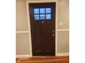 A dark wood front door with a window and trim at 2441 Northview Ave, Indianapolis, IN 46220