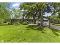 Single-story brick home with green lawn and mature tree near attached two-car garage at 2818 S Irwin St, Indianapolis, IN 46203