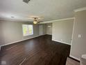 Bright and airy living room with modern dark wood flooring, neutral walls, and a ceiling fan at 3060 S Lyons Ave, Indianapolis, IN 46241
