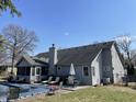 Rear exterior featuring a partially covered pool, screened in room, and seating on a grass lot at 36 Circle Dr, Carmel, IN 46032