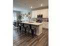 Spacious kitchen with an island, white cabinets, stainless steel appliances, and adjacent dining area at 3613 Chalmers Dr, Bargersville, IN 46106