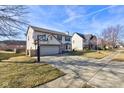 Suburban home featuring a basketball hoop, large driveway and an attached two-car garage at 917 Claiborne Ln, Lebanon, IN 46052