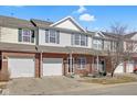 Charming two-story townhouse features a brick facade and a one-car garage, nestled under a partly cloudy sky at 9730 Prairie Smoke Dr, Noblesville, IN 46060