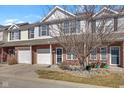 Charming two-story townhouse features a brick facade and a one-car garage, nestled under a partly cloudy sky at 9730 Prairie Smoke Dr, Noblesville, IN 46060