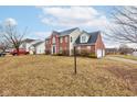 Lovely two-story home featuring a brick facade, attached garage, and manicured landscaping at 10046 Gate Dr, Indianapolis, IN 46239