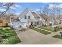 Inviting two-story home featuring a well-maintained lawn, a two-car garage, and a cozy front porch at 10706 Morristown Ct, Carmel, IN 46032