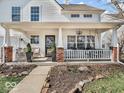 Relaxing front porch with brick pillars, a swing, and comfortable seating to enjoy the outdoors at 10706 Morristown Ct, Carmel, IN 46032