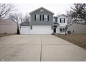 Charming two-story home with grey vinyl siding, white brick accents, and a spacious driveway at 12128 Princewood Ct, Fishers, IN 46037