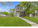 Charming two-story home with a well-manicured lawn and inviting walkway leading to the front door at 1538 Ringgold Ave, Indianapolis, IN 46203