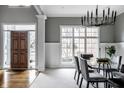 Elegant dining room with a modern chandelier, a glass table, and large windows at 1805 Braeburn Dr, Carmel, IN 46032