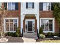 Inviting front entrance with a solid door, decorative sidelights, and manicured landscaping at 1805 Braeburn Dr, Carmel, IN 46032