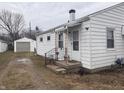 Exterior side view of home with white siding, detached garage, and yard at 1843 Bauer Rd, Indianapolis, IN 46218