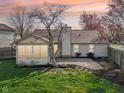 Backyard featuring a stone patio area and a partially enclosed sunroom, perfect for outdoor relaxation and entertaining at 2020 Cross Willow Ln, Indianapolis, IN 46239
