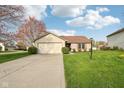 Traditional home with a well-maintained lawn, long driveway, and attached garage, offering curb appeal and convenience at 2020 Cross Willow Ln, Indianapolis, IN 46239