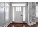 Bright foyer featuring white trim and wainscoting, gleaming hardwood floors, and elegant front door with sidelights at 2274 Finchley Rd, Carmel, IN 46032