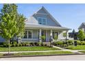 Inviting home with a covered porch, well-manicured lawn, and mature landscaping at 2274 Finchley Rd, Carmel, IN 46032