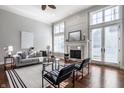 Light-filled living room boasts a fireplace, hardwood floors, neutral tones, and French doors leading to an outdoor space at 2274 Finchley Rd, Carmel, IN 46032