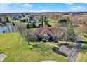 Aerial view showcases the home's beautiful landscape and well-manicured lawn with a pond nearby at 2605 Durbin Ct, Carmel, IN 46032