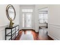 Inviting front foyer features gleaming hardwood floors, transom windows, and elegant console table at 3560 Cardinal Way, Carmel, IN 46074