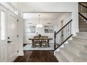 Elegant foyer with hardwood floors, staircase, and dining room view at 3905 Pelham Rd, Carmel, IN 46074