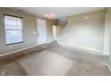 Inviting living room with a front door, interior door, neutral walls, carpet and staircase at 3941 Planewood Dr, Indianapolis, IN 46235