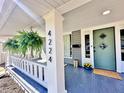 Inviting front porch with hanging plants, blue painted floor, and stylish front door with diamond windows at 4224 Cornelius Ave, Indianapolis, IN 46208