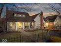 Charming home featuring a red brick chimney, inviting front porch with seating, and well-kept landscaping at 5055 Willow Rd, Zionsville, IN 46077