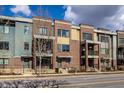 Attractive townhomes feature brick and siding exteriors and wrought iron railings, under a cloudy sky at 606 E 10Th St, Indianapolis, IN 46202