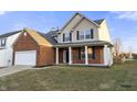 Lovely home with a brick and siding exterior, attached garage, and a covered front porch at 6311 Feather Run Dr, Indianapolis, IN 46237